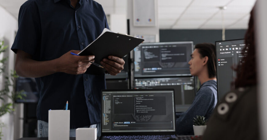 Software developer holding clipboard checking html code on terminal window